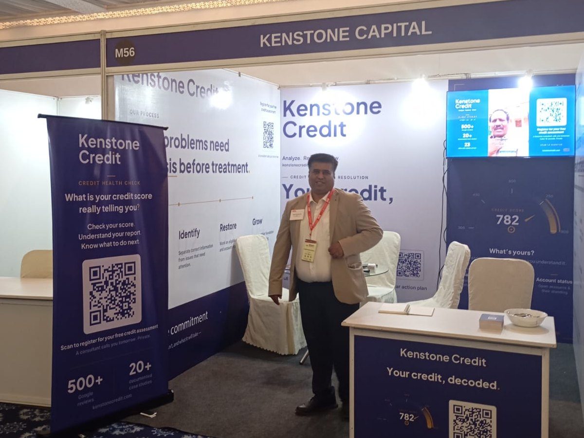 Harish Krishnamurthy at the Kenstone Credit stall, Stall M56, with the client-testimonial video loop playing on the wall-mounted screen